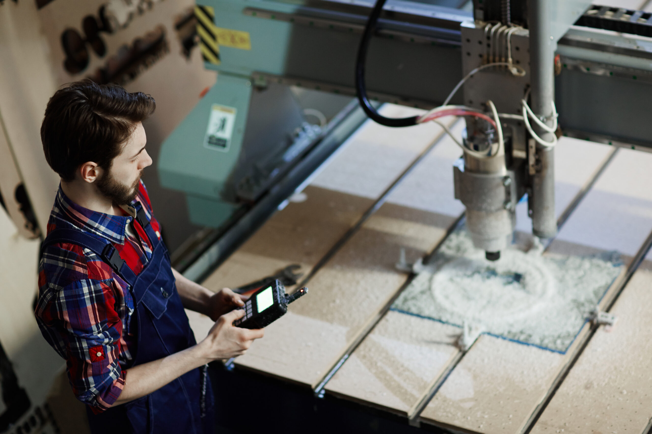 Factory technician monitoring CNC automation system with AI and collaborative robots in modern manufacturing facility